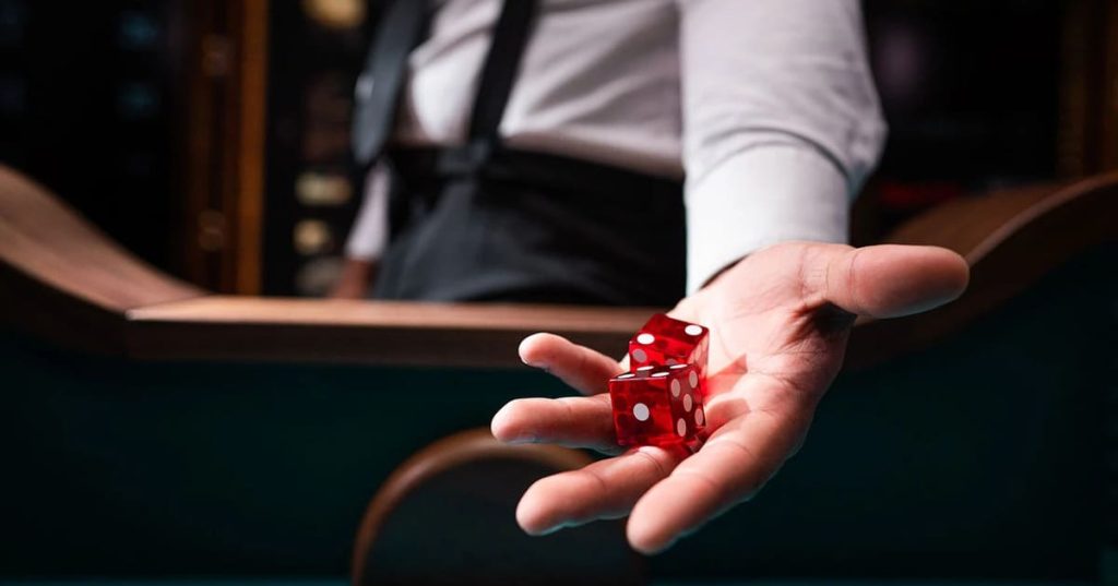 Скфзі dice in the dealer's hand.